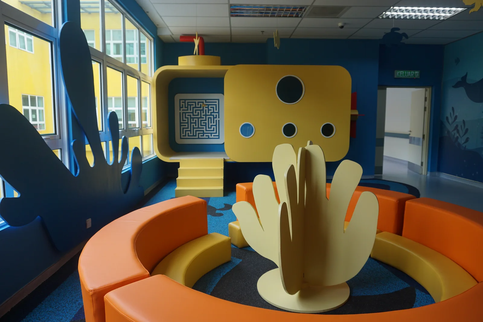 Installed play equipment and ocean-themed wall graphics at the hospital